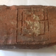The clay tablet with a game board etched onto it.